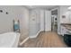 Luxurious bathroom featuring a large glass enclosed shower, dual granite vanities, and soaking tub at 8717 Emeraldwood Way, Land O Lakes, FL 34637