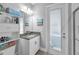 Bathroom features vanity with granite countertop, shelving, and an outdoor door to the lanai at 8717 Emeraldwood Way, Land O Lakes, FL 34637
