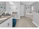 Luxurious bathroom featuring dual granite vanities, a soaking tub, and a glass-enclosed shower at 8717 Emeraldwood Way, Land O Lakes, FL 34637