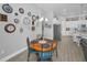 Dining area featuring round table, decoratively adorned wall clocks, and view into the kitchen at 8717 Emeraldwood Way, Land O Lakes, FL 34637