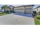 Long driveway leading up to a two-car garage, complemented by neat landscaping at 8717 Emeraldwood Way, Land O Lakes, FL 34637