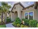 Close-up of the arched home entrance with tasteful landscaping and lush greenery at 8717 Emeraldwood Way, Land O Lakes, FL 34637