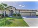 Beautiful home with a well-maintained lawn, mature palm trees, and a spacious three-car garage at 8717 Emeraldwood Way, Land O Lakes, FL 34637