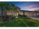 Charming home showcasing manicured lawn, palm trees, double door entrance, and a two-car garage at 8717 Emeraldwood Way, Land O Lakes, FL 34637