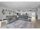 Bright living room featuring a gray sectional sofa and view into the open kitchen with white cabinets at 8717 Emeraldwood Way, Land O Lakes, FL 34637