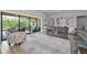 Bright living room featuring a gray sectional sofa and views of the outdoor pool area through large sliding glass doors at 8717 Emeraldwood Way, Land O Lakes, FL 34637