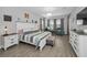 Spacious main bedroom with wood-look flooring, a large bed, and comfortable seating area at 8717 Emeraldwood Way, Land O Lakes, FL 34637