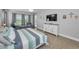 Bright main bedroom with wood-look flooring, a large bed, and comfortable seating area with pool views at 8717 Emeraldwood Way, Land O Lakes, FL 34637