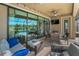 Inviting screened-in patio with comfortable seating and a view of the pool and lake at 8717 Emeraldwood Way, Land O Lakes, FL 34637