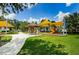 Playground with a gazebo and shaded seating areas surrounded by a green lawn and mature trees at 8717 Emeraldwood Way, Land O Lakes, FL 34637
