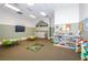 Inviting playroom features colorful furniture, well-stocked shelves and a TV for entertainment at 8717 Emeraldwood Way, Land O Lakes, FL 34637