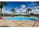 Community pool featuring palm trees, lounge chairs and an adjacent splashpad at 8717 Emeraldwood Way, Land O Lakes, FL 34637
