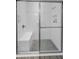 Modern shower with tiled walls, a built-in bench, and sliding glass doors at 8717 Emeraldwood Way, Land O Lakes, FL 34637