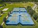Aerial view of tennis and basketball courts featuring well-maintained surfaces and professional equipment at 8717 Emeraldwood Way, Land O Lakes, FL 34637