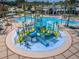 Community waterpark featuring slides, splash pad, and a large pool surrounded by palm trees and lounge chairs at 8717 Emeraldwood Way, Land O Lakes, FL 34637