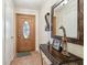 Inviting entryway featuring an oval window wood door, tile floors, and decorative mirror at 8728 Mcadam Pl, Tampa, FL 33634