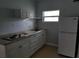 This kitchen features granite countertops, white cabinets, cooktop and stainless refrigerator at 8728 Mcadam Pl, Tampa, FL 33634