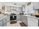 This bright kitchen features gray cabinets, tile countertops, and stainless steel appliances at 8728 Mcadam Pl, Tampa, FL 33634
