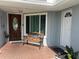 Front porch features a wooden bench, tiled flooring, and a view of both entry doors at 8728 Mcadam Pl, Tampa, FL 33634