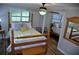 Bedroom featuring a four poster bed, wood floors, a window with wooden blinds and a closet with mirrored doors at 915 Rolling Hills Dr, Palm Harbor, FL 34683