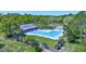 Aerial view of the Westlake Village community pool with a clubhouse and surrounding greenery at 915 Rolling Hills Dr, Palm Harbor, FL 34683