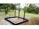 Community upper body exercise station with wood chip ground covering and lush green grass at 915 Rolling Hills Dr, Palm Harbor, FL 34683
