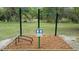 Community upper body exercise station with instructions and wood chip ground covering at 915 Rolling Hills Dr, Palm Harbor, FL 34683