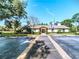 Exterior view of community building, well-maintained landscaping, and ample parking spaces at 915 Rolling Hills Dr, Palm Harbor, FL 34683