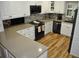 Bright kitchen features white cabinets, stone countertops, stainless steel appliances, and wood flooring at 915 Rolling Hills Dr, Palm Harbor, FL 34683