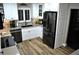 Modern kitchen featuring white cabinetry, a black stainless steel refrigerator, and updated countertops at 915 Rolling Hills Dr, Palm Harbor, FL 34683