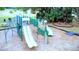 Playground with multiple slides, climbing structure, and pea gravel ground cover for a safe play environment at 915 Rolling Hills Dr, Palm Harbor, FL 34683