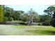Community pond surrounded by mature trees and lush landscaping with a well-manicured lawn at 915 Rolling Hills Dr, Palm Harbor, FL 34683