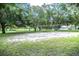 Community outdoor sand volleyball court for residents with mature trees and grassy areas at 915 Rolling Hills Dr, Palm Harbor, FL 34683