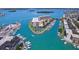 Aerial view of waterfront property with a marina, tennis court, and residential buildings at 1 Key Capri # 303E, Treasure Island, FL 33706