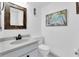Clean bathroom featuring a vanity with a sink, toilet, and framed tropical beach painting at 1 Key Capri # 303E, Treasure Island, FL 33706