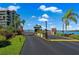 Gated community entrance with lush landscaping and waterfront views at 1 Key Capri # 303E, Treasure Island, FL 33706
