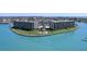 Beautiful exterior view of the condominium complex featuring lush landscaping, waterfront views and community pool at 1 Key Capri # 303E, Treasure Island, FL 33706