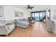 Airy living room with neutral tones, wood floors, comfortable seating, and expansive water views at 1 Key Capri # 303E, Treasure Island, FL 33706