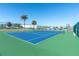 Tennis court surrounded by lush green foliage and a partial view of the marina in the distance at 1 Key Capri # 303E, Treasure Island, FL 33706