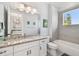 Bright bathroom with granite vanity, white cabinets and bathtub with gray tile surround at 101 Biscayne Ave, Tampa, FL 33606