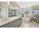 Luxurious bathroom with a double vanity, soaking tub, and glass-enclosed shower at 101 Biscayne Ave, Tampa, FL 33606