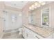 Well lit bathroom features a glass shower, granite vanity with modern fixtures and white cabinetry at 101 Biscayne Ave, Tampa, FL 33606