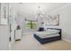 Cozy bedroom with unique light fixture, blue bed, and a window with neighborhood views at 101 Biscayne Ave, Tampa, FL 33606