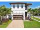 Charming two-story home featuring a balcony, two-car garage, and mature palm trees at 101 Biscayne Ave, Tampa, FL 33606