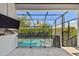 Screened in balcony overlooks a pool with hot tub, privacy hedges, and a patio area at 101 Biscayne Ave, Tampa, FL 33606