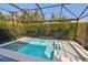 Beautiful screened-in pool with spa and tranquil waterfall feature amidst lush landscaping at 101 Biscayne Ave, Tampa, FL 33606