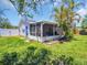 Backyard showcasing a screened patio and lush tropical landscaping at 1011 Coldstream Ct, Tarpon Springs, FL 34689