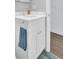 Bathroom vanity features a white cabinet, hardware, sink, faucet, and wood-look flooring at 1011 Coldstream Ct, Tarpon Springs, FL 34689