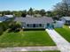 Well-maintained home with manicured lawn, a blue door, and cozy blue Adirondack chairs at 1011 Coldstream Ct, Tarpon Springs, FL 34689