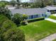 Inviting home with a well-manicured lawn and a blue front door amidst lush landscaping at 1011 Coldstream Ct, Tarpon Springs, FL 34689
